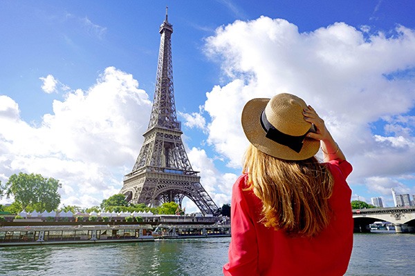 Woman with French hat looking at Eiffel Tower